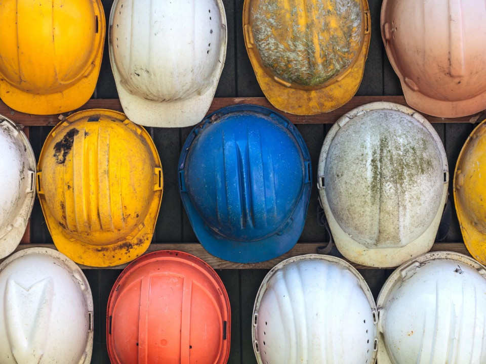 Historic image of construction workers wearing safety helmets while building a bridge