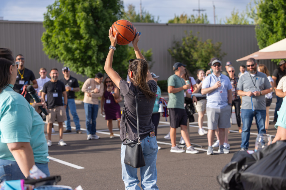Raffle winner hoists Damian Lillard-signed basketball above head and the crowd cheers.